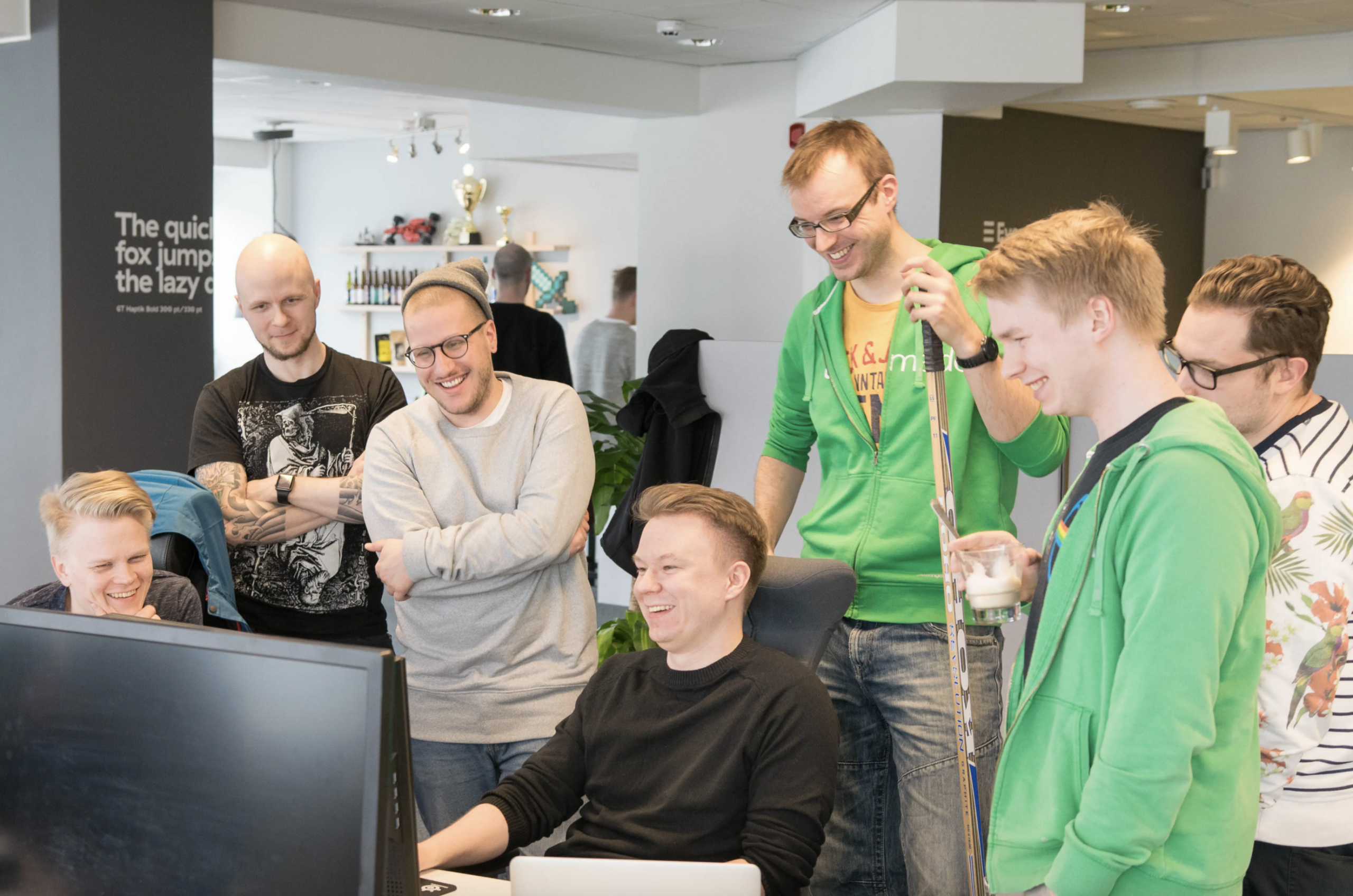 Evermade's team at the office, looking at one's screen