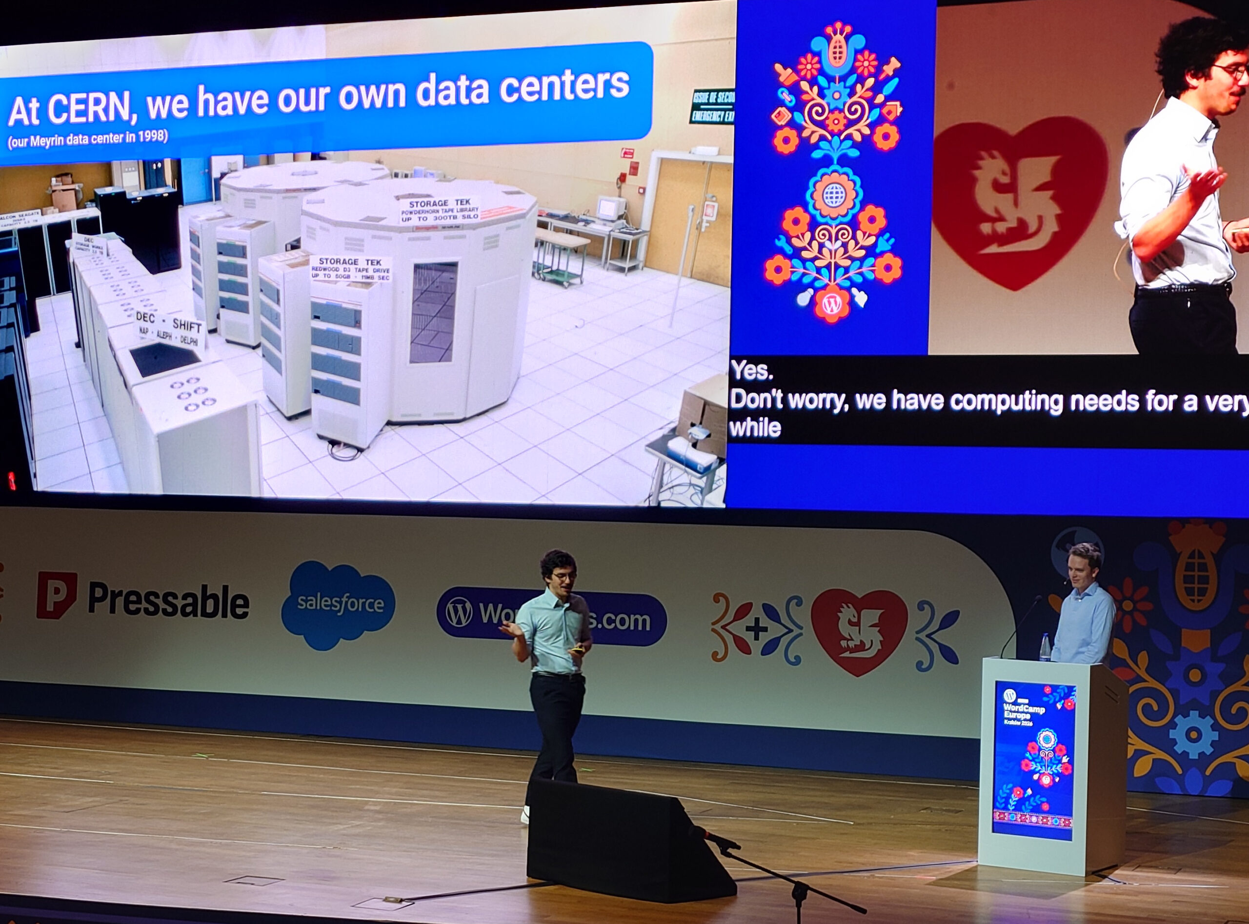 Esiintyjä lavalla WordCamp Europe 2026 -tapahtumassa, suuri näyttö taustalla näyttää CERNin datakeskuksen kuvan ja esitysdioja, etualalla podium ja tapahtuman sponsoreiden logot.