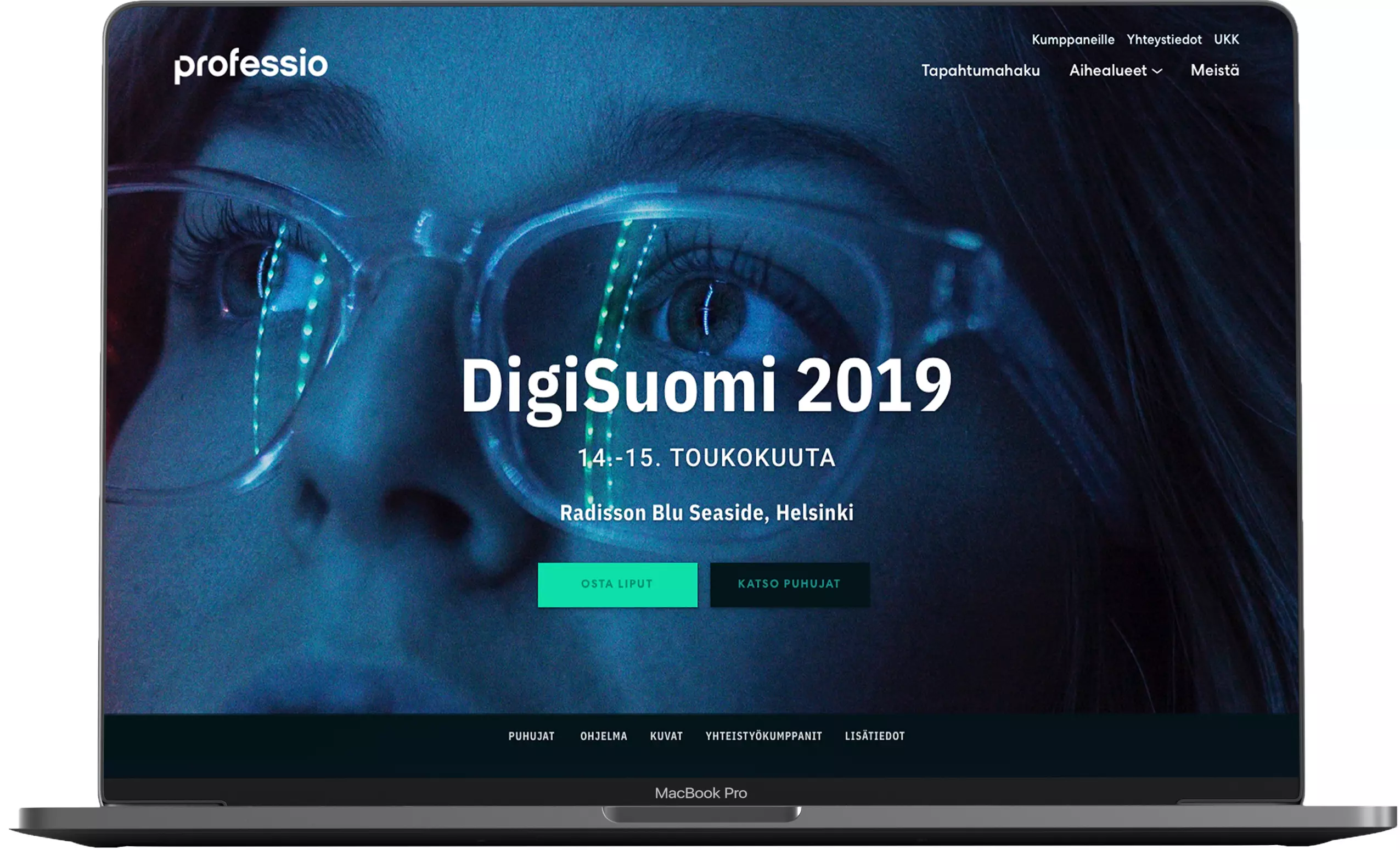 MacBook Pron näytöllä verkkosivun mockup: Professio-logo ylävasemmalla, sinisävyinen lähikuva naisesta silmälaseissa ja keskellä teksti "DigiSuomi 2019" sekä tapahtuman päivämäärät 14.–15. toukokuuta ja sijainti Radisson Blu Seaside, Helsinki, sekä kaksi toimintopainiketta.