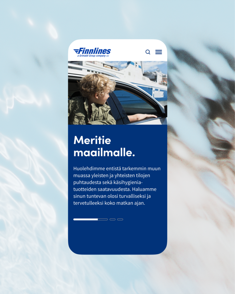 Älypuhelinnäyttö, jossa Finnlinesin mobiilisivu: yläreunassa Finnlines-logo, kuva autosta ikkunasta kurkistavasta lapsesta ja taustalla laiva, sininen tekstilaatikko otsikolla "Meritie maailmalle." ja leipätekstillä tietoa matkustusturvallisuudesta ja hygieniasta, taustalla vaaleansininen veden kuvio.